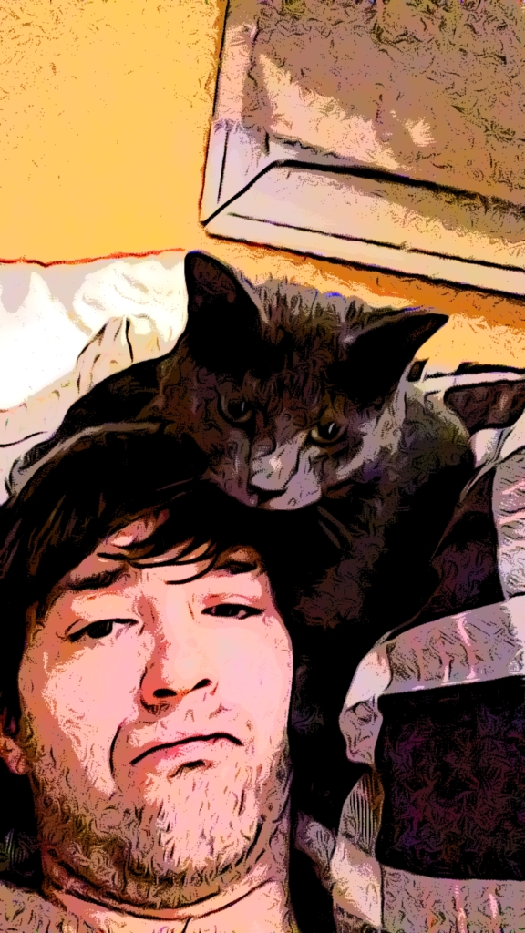 Swlfie with cat on my head while laying down on the bed